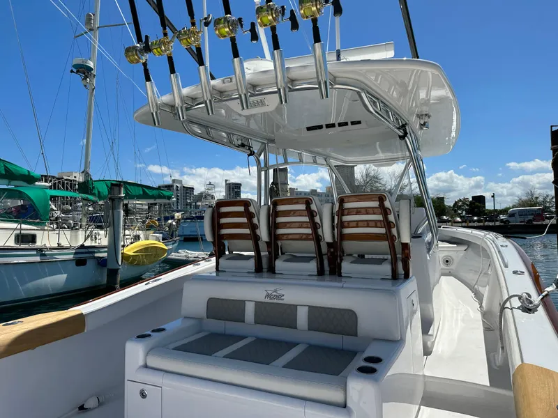 Slide: The Image of 2022 Weaver Center Console boat with fishing rods, docked at marina under clear blue sky. - 5