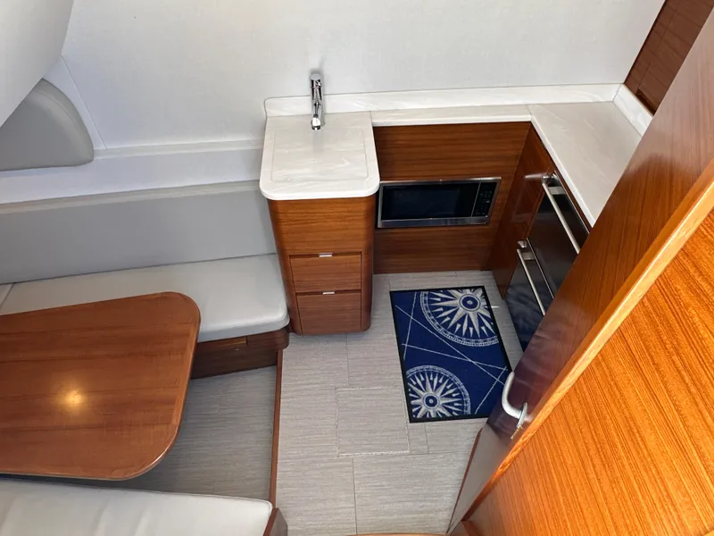 Slide: The Image of 2022 Weaver Center Console interior with wood finish, kitchenette, and seating area. - 8