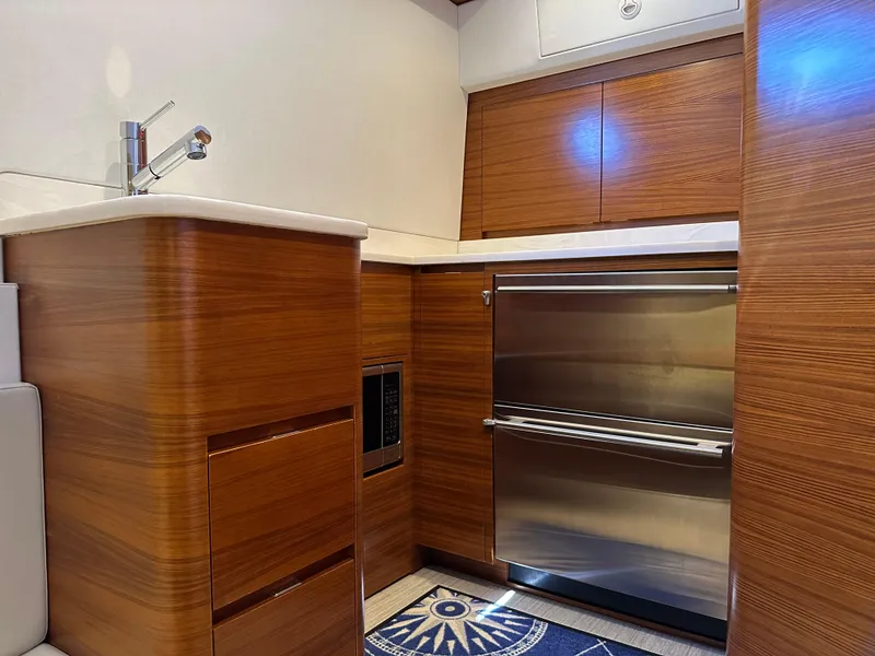 Slide: The Image of 2022 Weaver Center Console interior with wood cabinetry and stainless steel appliances. - 9