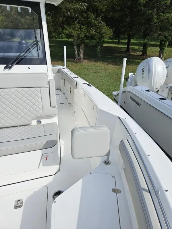 Slide: The Image of 2024 Pursuit S 248 Sport boat interior with seating and storage, parked outdoors. - 6