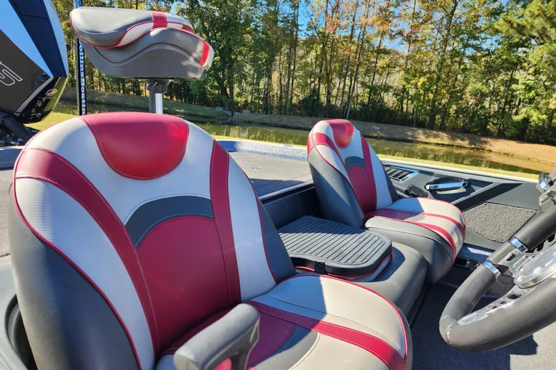Slide: The Image of 2019 Ranger Z520L boat interior with red and gray seats by a lake. - 12