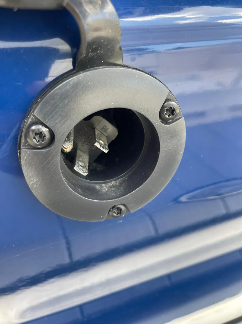 Slide: The Image of Close-up of a 2024 Skeeter SX 2350 boat power outlet on blue surface. - 16