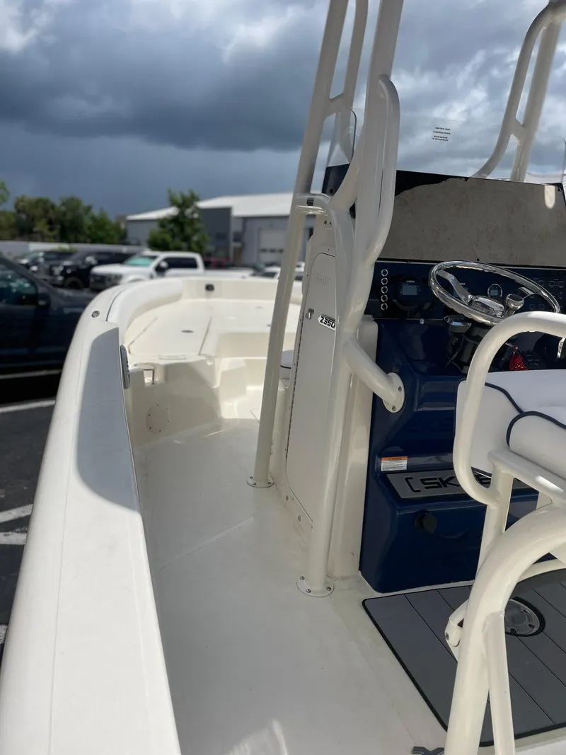 Slide: The Image of 2024 Skeeter SX 2350 boat interior with steering console, under cloudy sky. - 6