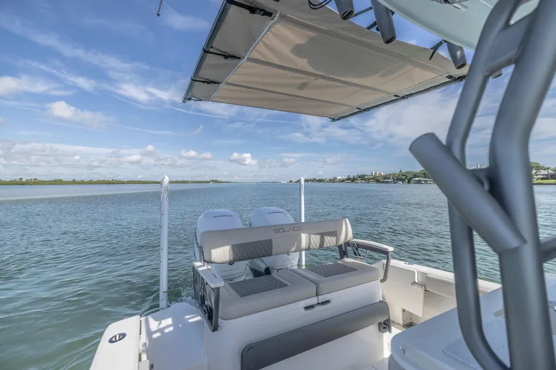 Slide: The Image of 2025 Solace 30 HCS boat on calm water with canopy and seating. - 5