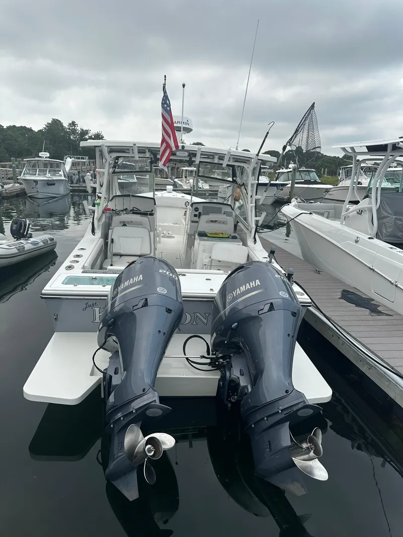 Slide: The Image of 2021 Parker 2540 DC boat with twin Yamaha engines docked in a marina. - 2