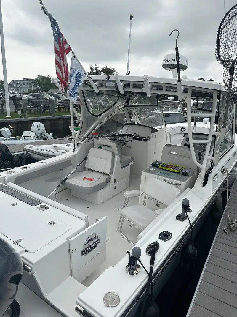 Slide: The Image of 2021 Parker 2540 DC boat docked, featuring spacious seating and fishing equipment. - 3