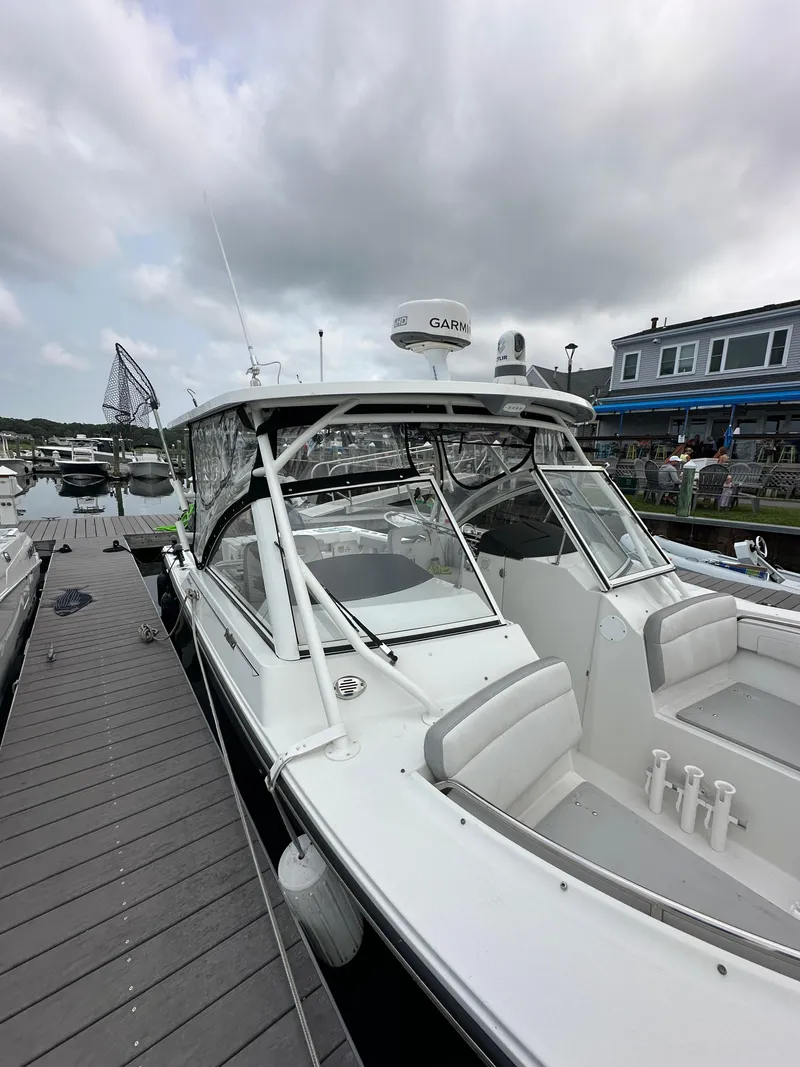 Slide: The Image of 2021 Parker 2540 DC boat docked at marina under cloudy sky. - 5