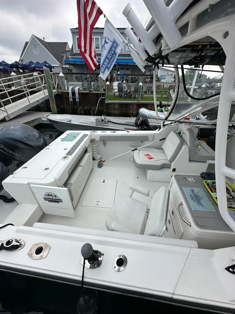 Slide: The Image of 2021 Parker 2540 DC boat docked, featuring spacious seating and American flag. - 6