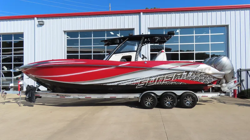 Slide: The Image of 2014 Sunsation 34 CCX boat in vibrant red on a trailer outside a garage. - 1