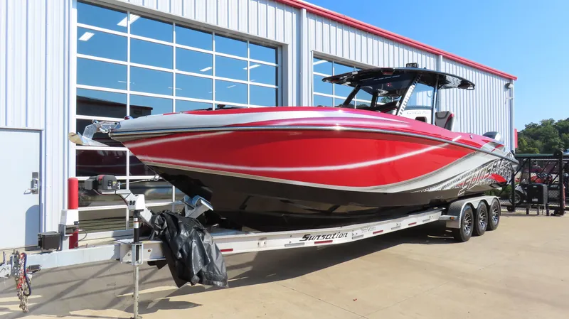 Slide: The Image of 2014 Sunsation 34 CCX boat on trailer outside a showroom under a clear blue sky. - 2