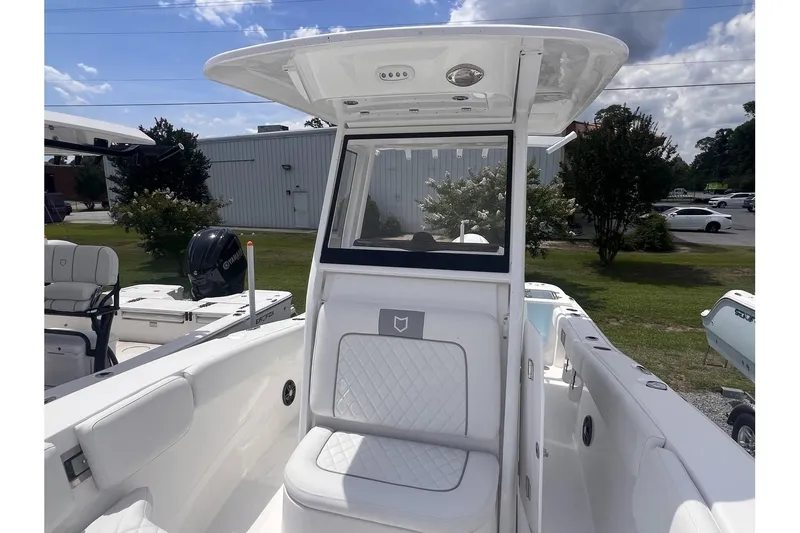 Slide: The Image of 2025 Sea Fox 228 boat interior with white seating and T-top under a blue sky. - 13