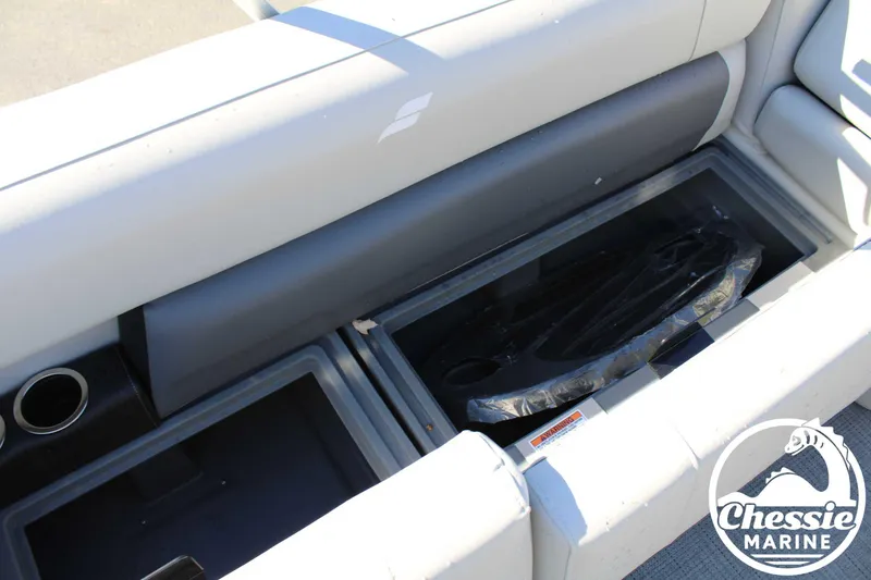 Slide: The Image of 2024 Starcraft Pontoon LX 22 R interior storage compartment with cup holder, Chessie Marine logo. - 16