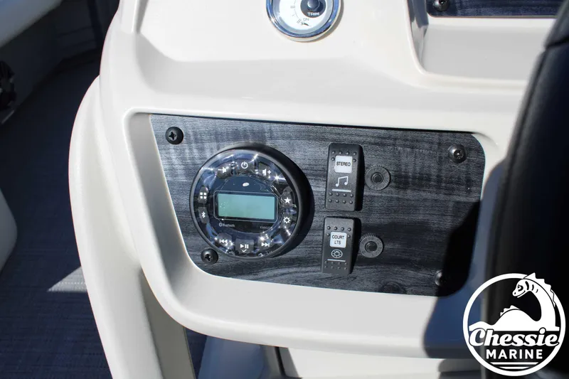 Slide: The Image of 2024 Starcraft Pontoon LX 22 R dashboard with stereo controls and Chessie Marine logo. - 23