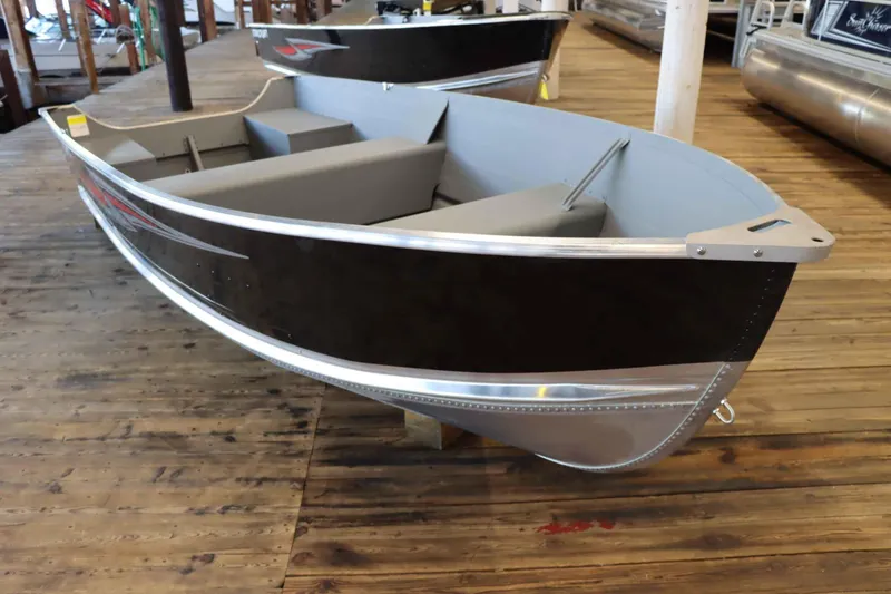 Slide: The Image of 2025 Starcraft 14 SF TS SS boat displayed on wooden dock indoors. - 2