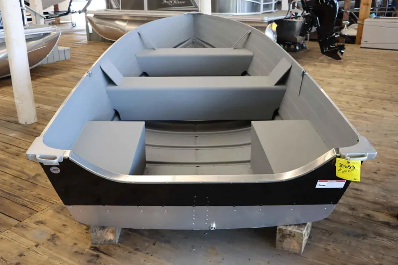 Slide: The Image of 2025 Starcraft 14 SF TS SS aluminum boat on wooden blocks in showroom. - 3
