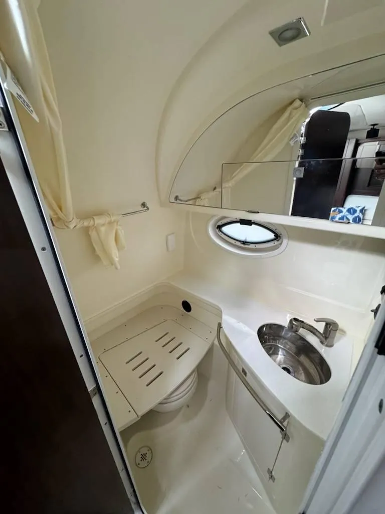 Slide: The Image of 2016 Monterey 355SY yacht bathroom with sink, toilet, and porthole window. - 15