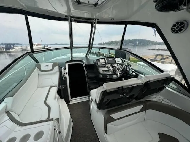 Slide: The Image of 2016 Monterey 355SY yacht cockpit with modern controls and seating, docked by a scenic waterfront. - 5