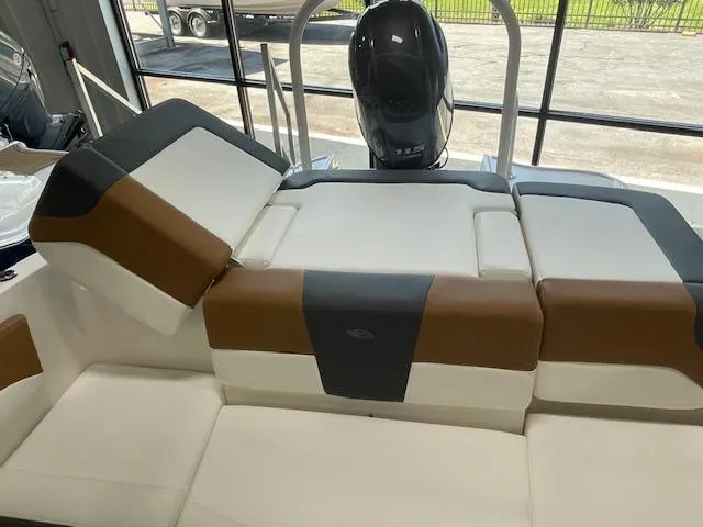 Slide: The Image of 2025 Chaparral 19 SSi OB boat interior with cushioned seating and outboard motor. - 7