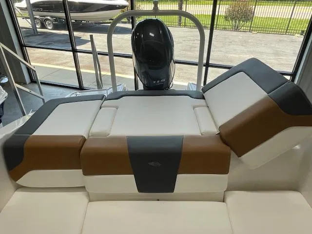 Slide: The Image of 2025 Chaparral 19 SSi OB boat interior with cushioned seating and outboard motor. - 8