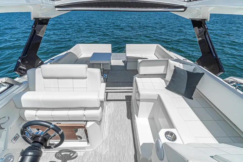Slide: The Image of 2017 Cruisers Yachts 390 Express Coupe interior with white seating, steering wheel, and ocean view. - 17