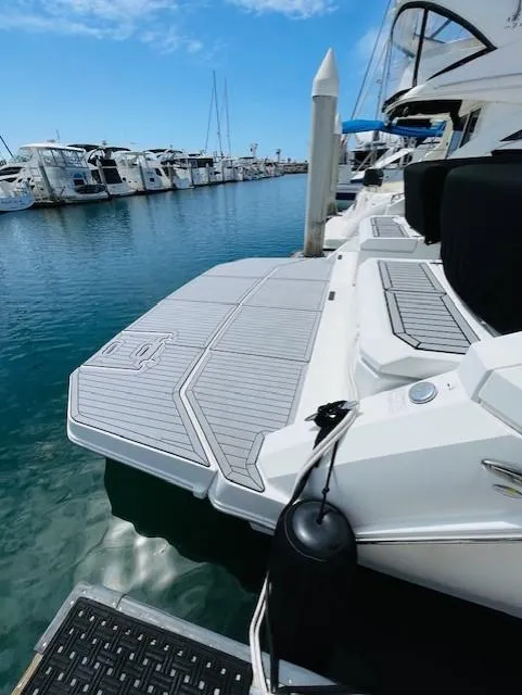 Slide: The Image of 2017 Cruisers Yachts 390 Express Coupe docked at marina, showcasing spacious swim platform. - 21