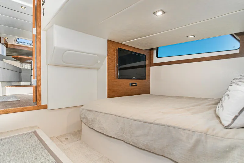 Slide: The Image of 2017 Cruisers Yachts 390 Express Coupe interior cabin with bed and TV. - 34