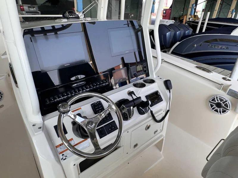 Slide: The Image of 2022 Cobia 280 Center Console boat dashboard with steering wheel and controls. - 16