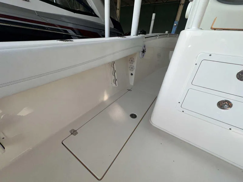 Slide: The Image of 2022 Cobia 280 Center Console boat interior with storage compartments. - 18