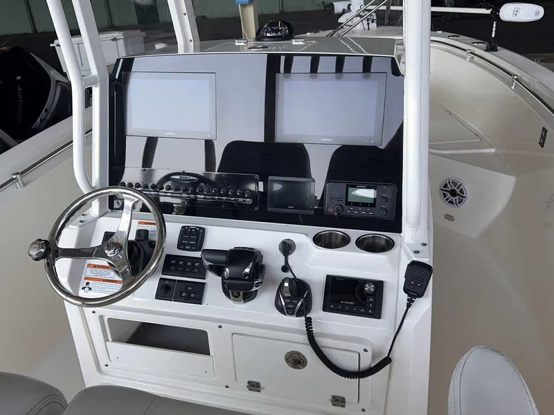 Slide: The Image of 2022 Cobia 280 Center Console boat dashboard with dual screens and controls. - 19