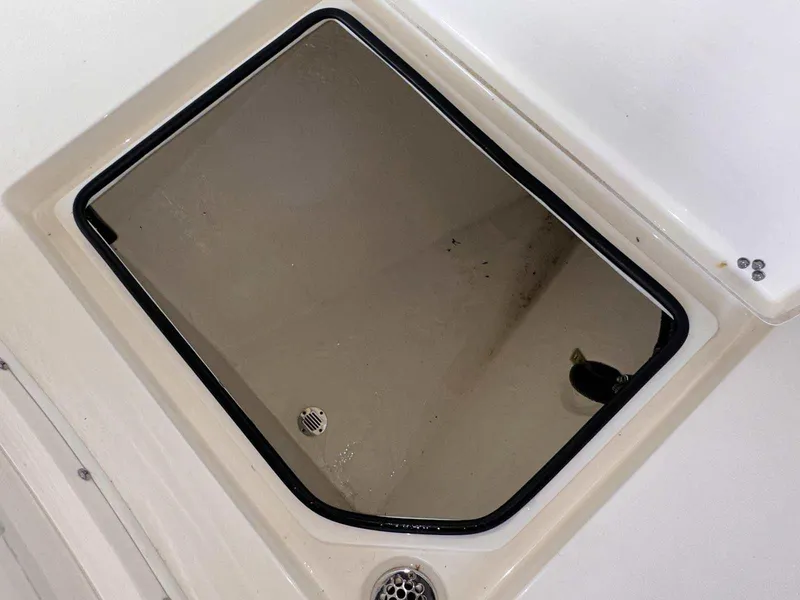 Slide: The Image of Cobia 280 Center Console 2022 boat hatch with black trim and drainage. - 27
