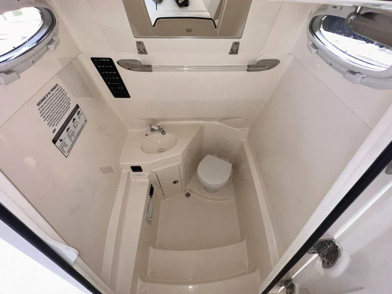 Slide: The Image of 2022 Cobia 280 Center Console boat interior bathroom with sink and toilet. - 28