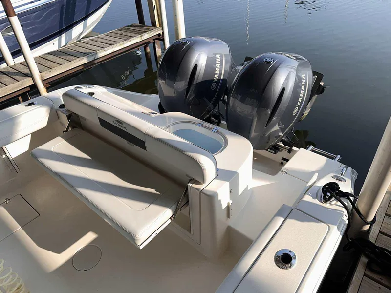 Slide: The Image of 2022 Cobia 280 Center Console boat with twin Yamaha engines docked by the water. - 3