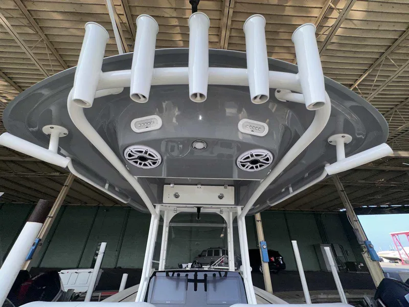 Slide: The Image of 2022 Cobia 280 Center Console boat with rod holders and speakers under a canopy. - 9