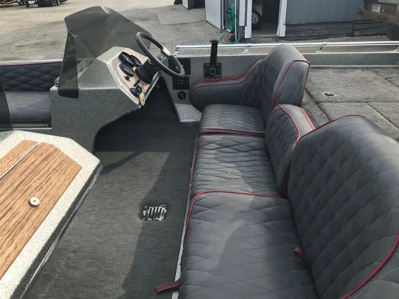 Slide: The Image of 1990 Ranger 375V boat interior with gray quilted seats and steering console. - 10