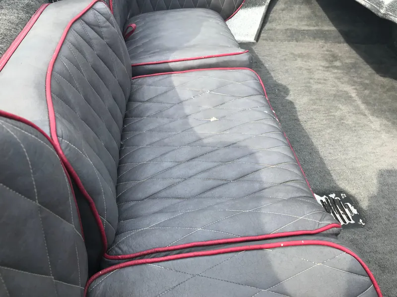 Slide: The Image of 1990 Ranger 375V boat interior with quilted gray seats and red trim. - 14