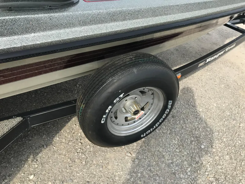 Slide: The Image of 1990 Ranger 375V boat trailer with Goodyear tire on gravel surface. - 26