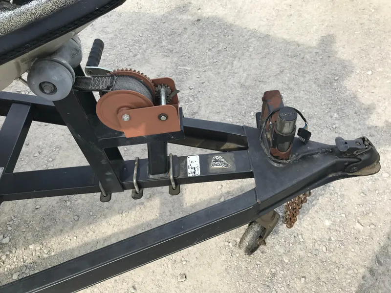 Slide: The Image of Trailer hitch and winch of a 1990 Ranger 375V boat on gravel surface. - 27