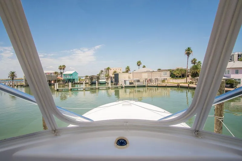 Slide: The Image of View from 2014 Hatteras 63 GT yacht, overlooking serene waterfront and palm trees. - 13