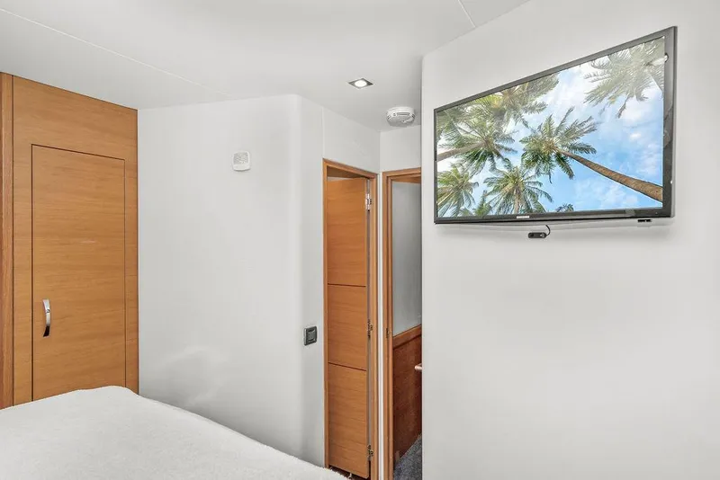 Slide: The Image of Interior of 2014 Hatteras 63 GT yacht with wall-mounted TV and wooden accents. - 35