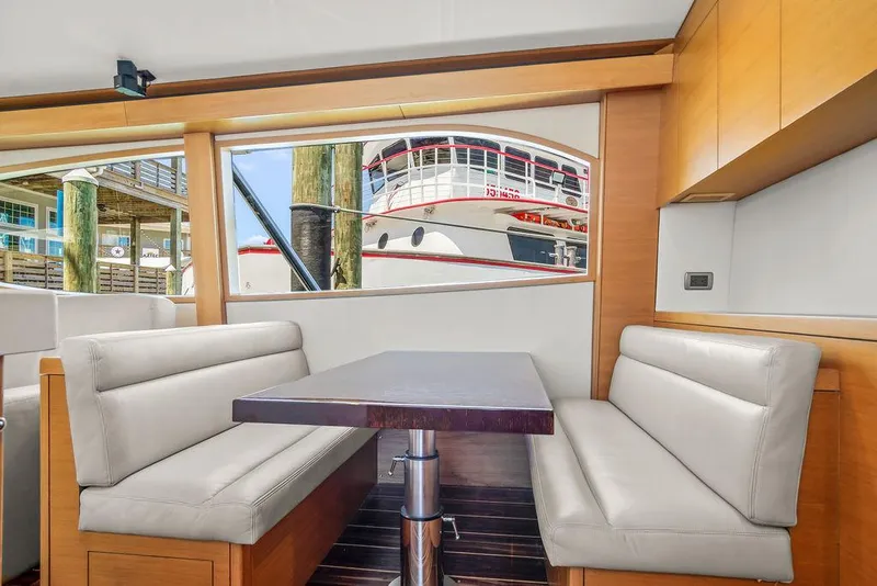 Slide: The Image of Interior of 2014 Hatteras 63 GT yacht with dining area and window view. - 45