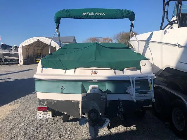 Slide: The Image of 2005 Four Winns 180 Horizon LE boat with green cover, parked outdoors. - 11