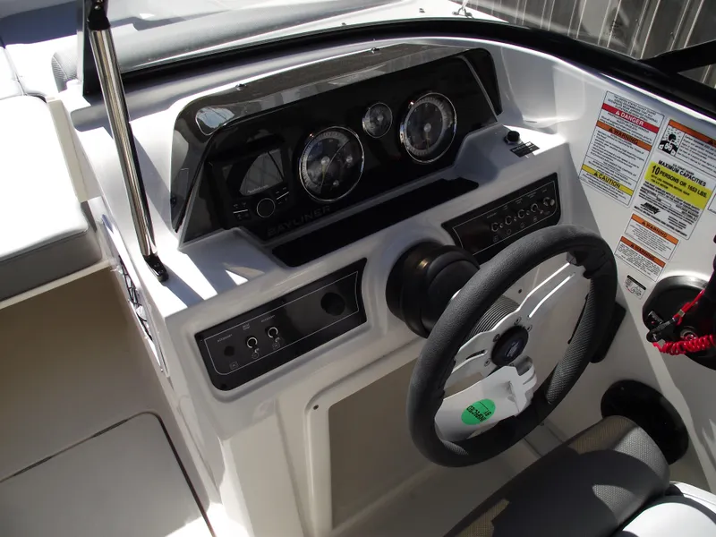 Slide: The Image of 2025 Bayliner D20 boat dashboard with steering wheel and control panel. - 10