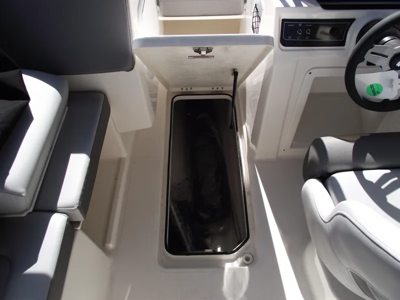 Slide: The Image of 2025 Bayliner D20 boat interior storage compartment with seating and steering wheel. - 15