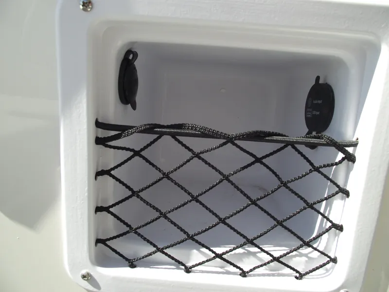Slide: The Image of Storage compartment with netting on a 2025 Bayliner D20 boat. - 31