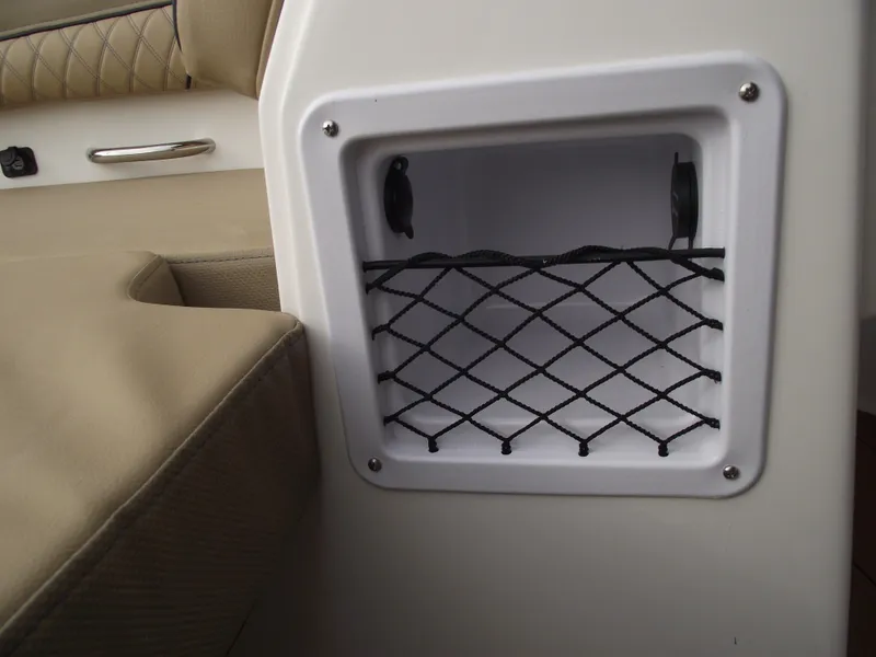 Slide: The Image of Storage compartment with netting on 2025 Bayliner D22 boat interior. - 10