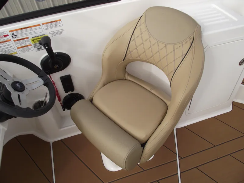 Slide: The Image of 2025 Bayliner D22 boat interior with beige captain's chair and steering wheel. - 12