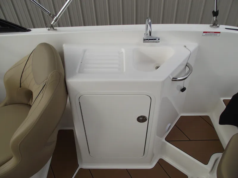 Slide: The Image of 2025 Bayliner D22 boat interior with sink and seating area. - 17