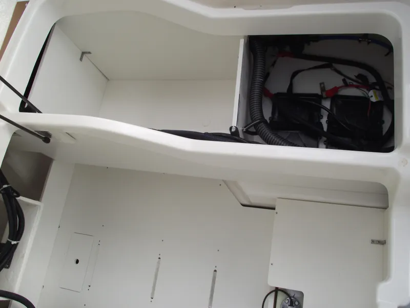Slide: The Image of 2025 Bayliner D22 boat interior storage compartment with wiring and battery setup. - 24