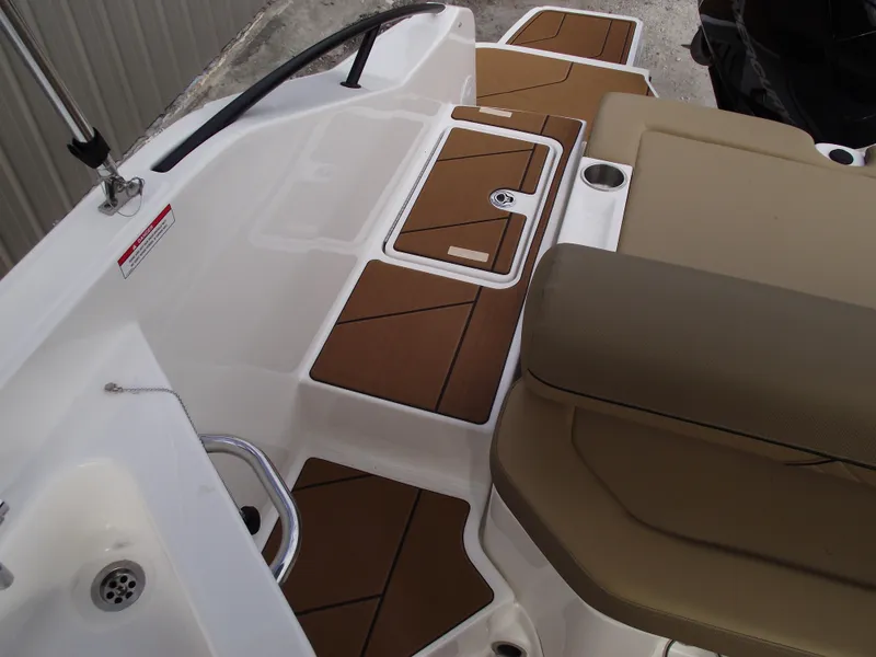 Slide: The Image of 2025 Bayliner D22 boat interior with tan seating and brown deck accents. - 25