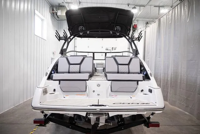 Slide: The Image of 2024 Yamaha Boats 255XE, rear view in a garage, showcasing seating and design features. - 3